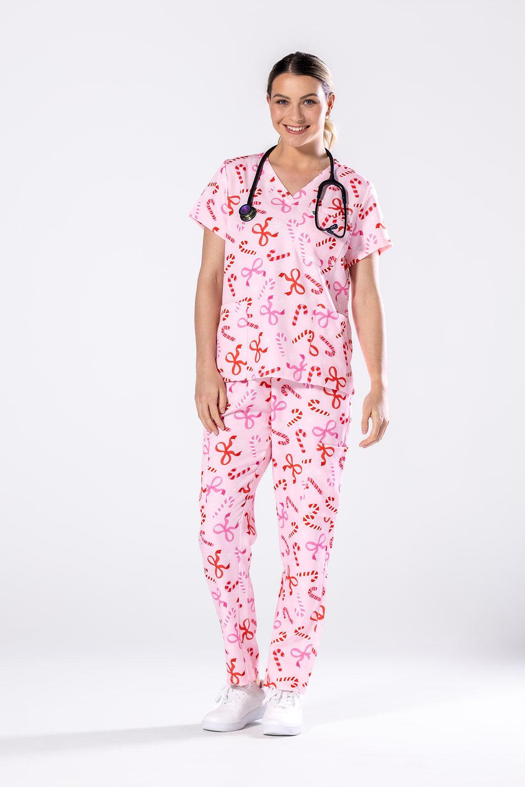 Person wearing a pink medical scrub set with a white background